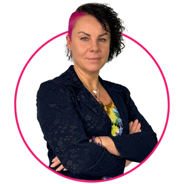 Zespół 10 Pewna siebie kobieta z kręconymi czarnymi włosami i jednym pasemkiem w kolorze jasnego różu stoi ze skrzyżowanymi ramionami. Nosi ciemną marynarkę na kolorowym topie i ma warstwowe naszyjniki. Jest otoczona jasnoróżową okrągłą ramką na białym tle.